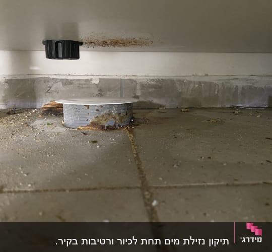 צינור ניקוז מתחת לכיור עם סימני חלודה